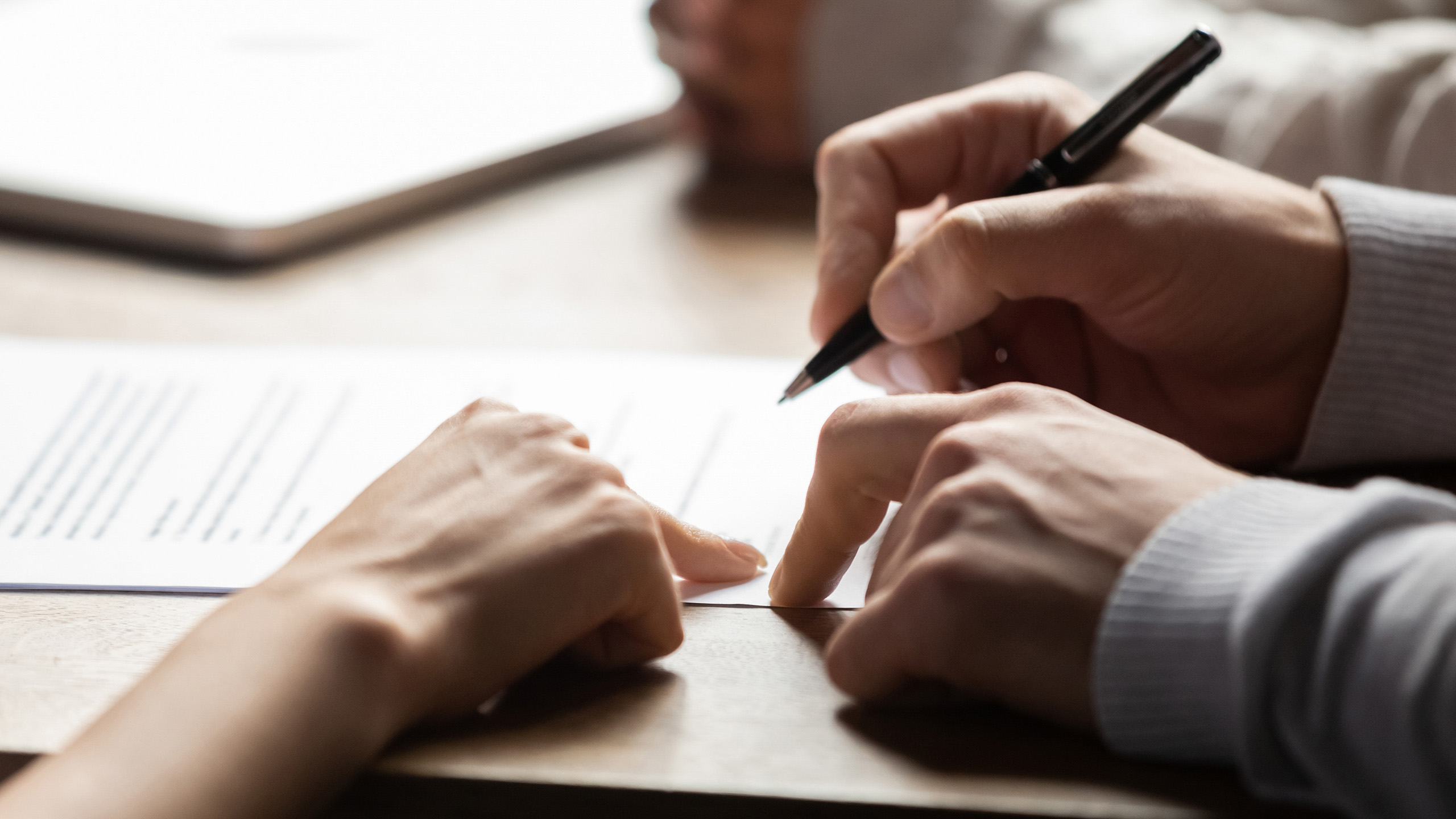 Solicitor pointing at contract showing client where to write signature